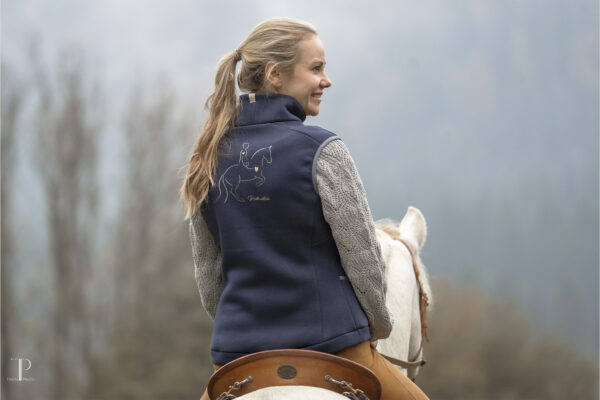 Lisa Jost präsentiert ihre neue Reitkunstliebe Weste reitend auf Jaguar von hinten